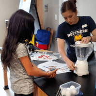 Home educator with student using a blender